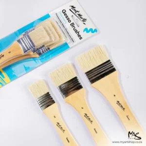 There is a full set of Mont Marte Discovery Gesso Brushes coming in diagonally from the top left hand side of the frame. There are 3 loose brushes below that. The largest brush is to the right, the medium sized brush is in the middle and the smallest brush is to the left. They are laying on a white background and it is a birds eye view. The image is cut off by the frame.