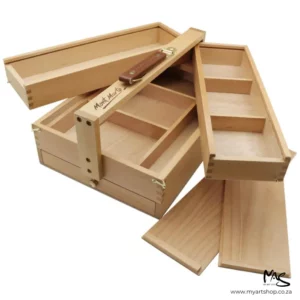 An open Mont Marte Signature Multi Purpose Art Box is shown diagonally across the center of the frame. The bos has 3 tiers and the top tiers are opened to show the storage inside. The box is wooden and has a brown leather carry handle. The image is center of the frame and on a white background.