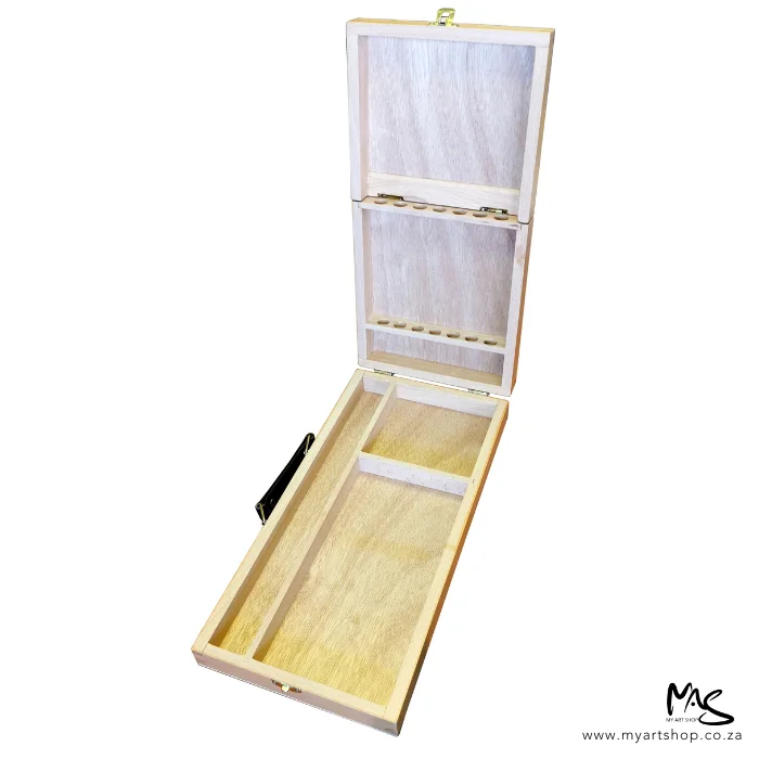 wooden-paint-brush-box-04 A single Wooden Paint Brush Box is shown in the center of the frame. The box is open and you can see the storage divisions in the bottom of the box, as well as the hinged lid that holds the paint brushes. There is a handle on the left hand side of the box. The image is on a white background.