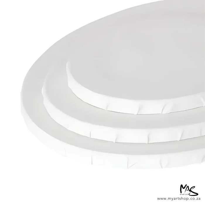 dala-oval-stretched-canvas-04 There are 3 Dala Oval Stretched Canvas coming out of the top right hand corner of the frame. The canvases are white and the largest one is at the bottom and the smallest one on top. The canvases are cut off by the corner of the frame. On a white background.