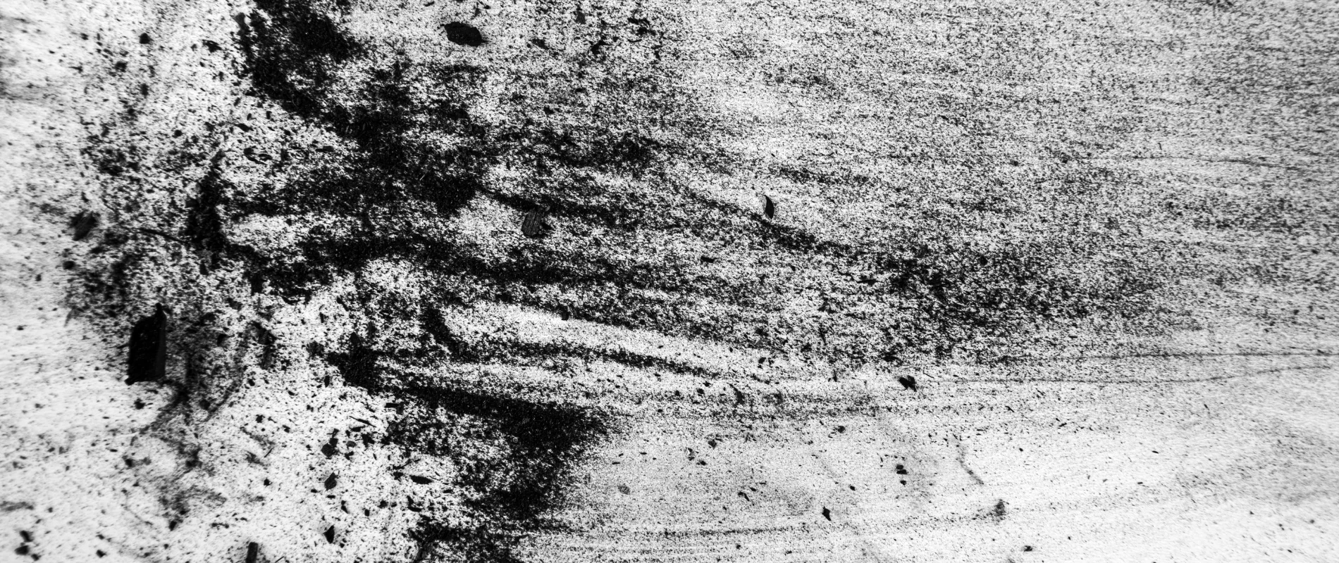 Coates Willow Charcoals The Connoisseurs Choice. this image shows charcoal that has been applied to paper and blended around. the colour is black against the white paper and there are grains of charcoal present in the image