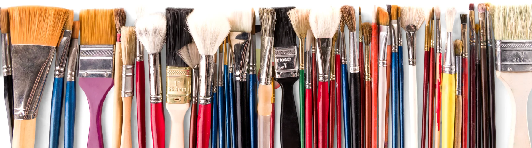 paint-brush-sets-for-your-masterpieces. across the whole image there is an assortment of different types of brushes. different sizes, shapes, colours, hair types. all laid out in a row. on a white background