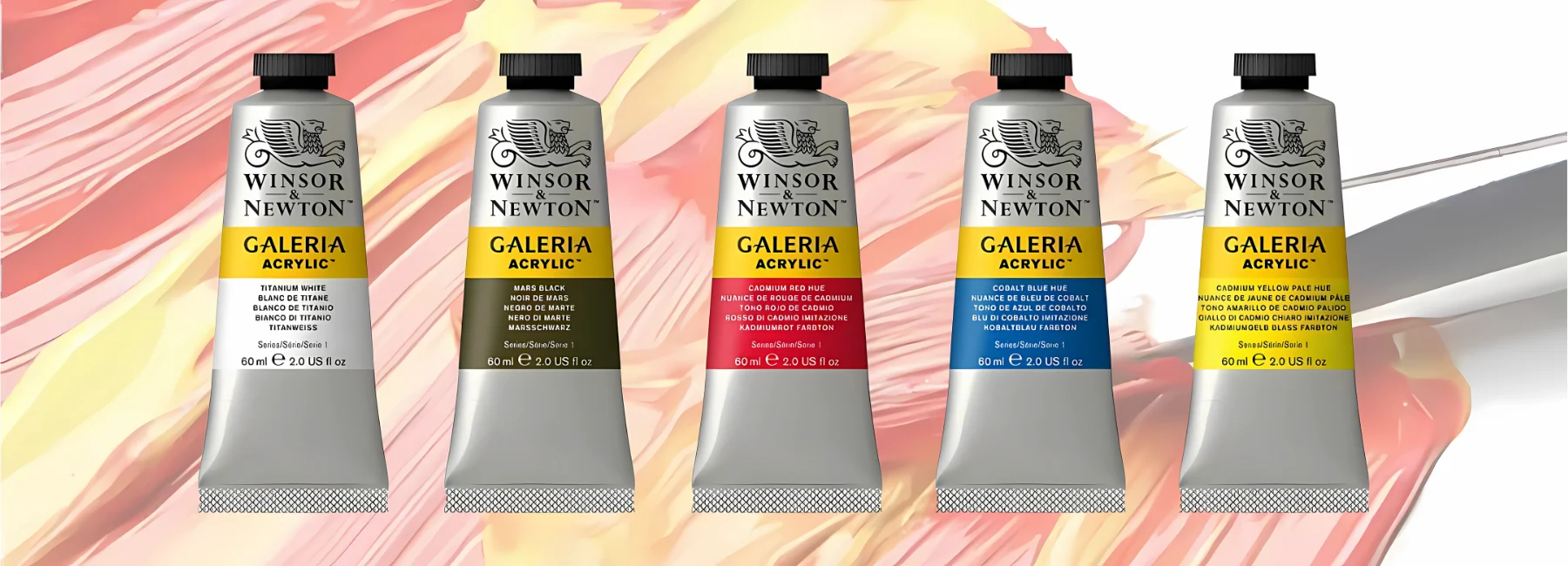 winsor-and-newton-galeria-acrylic-paint-dive-into-creativity. in a straight line across the center of the image are five tubes of galeria acrylic paint in a row. they have silver tubes, with coloured labels showing what colour is inside of them and black caps. they are sitting infront of a muted picture of the paint that is on a canvas and being smeared around with a brush