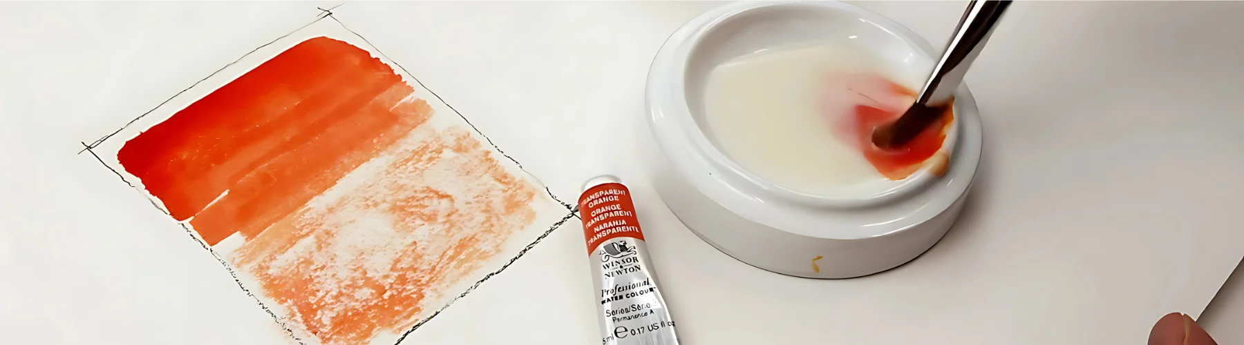 zellen-watercolour-mediums-unleashed. in the center of the image is a tube of watercolour paint and next to it on the left is a colour swatch in orange on the right is a palette with the paint inside and some medium being mixed together. on a white background