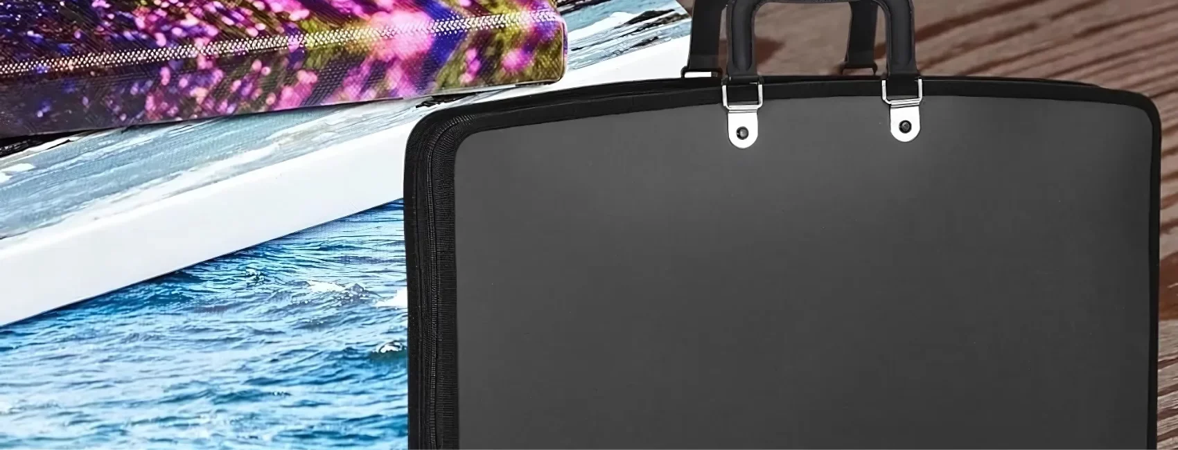 art-portfolio-cases-armor-up-your-artistry. the image is a close up of a portfolio bag that is closed and on the right hand side. the left hand side has three different canvases with images painted on it