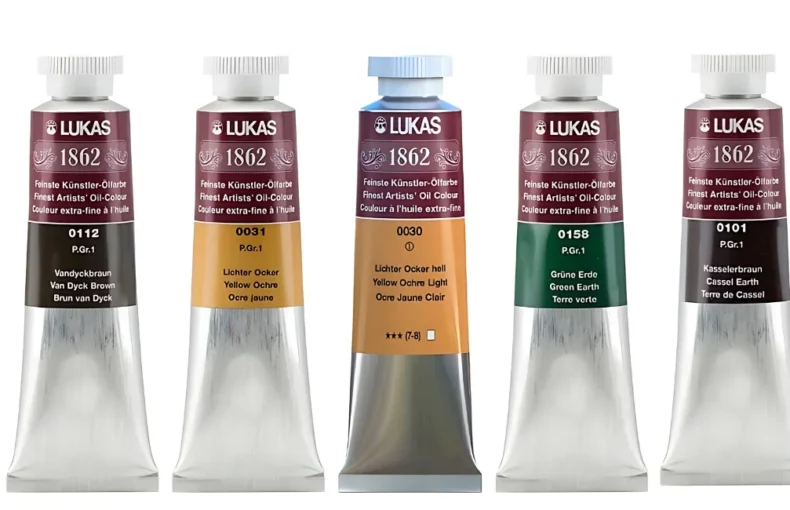 lukas-1862-oil-paint-review-for-art-enthusiasts. there are 9 lukas 1862 tubes lined up across the center of the image. they are standing with their caps facing the top. they have silver tubes and coloured labels with white writing
