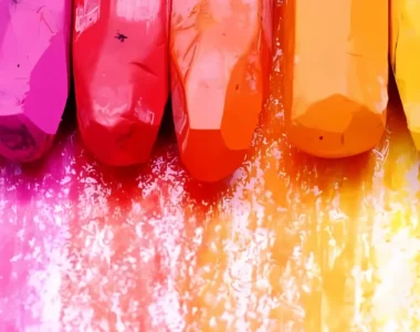 oil-pastels-elevate-your-art-game. the image is a close up of a rainbow order of oil pastels theat have been coloured with the same colour of each pastel underneath them to make a rainbow. they are at the top of the image.