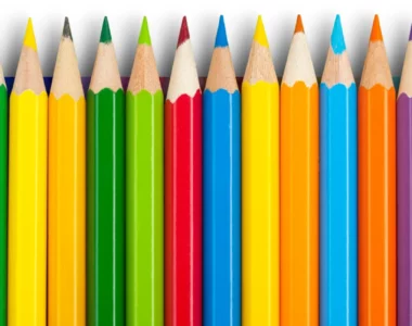 pastel-pencil-sets-an-exploration. the image shows a binch of brightly coloured pencils in a row in a rainbow order. they are all nib facing towards the top of the image. they are in a bunch of different colours and look sharp and neat