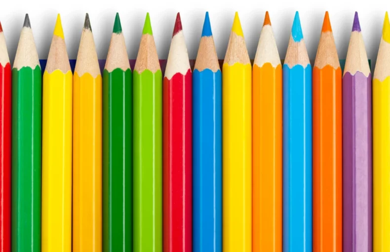 pastel-pencil-sets-an-exploration. the image shows a binch of brightly coloured pencils in a row in a rainbow order. they are all nib facing towards the top of the image. they are in a bunch of different colours and look sharp and neat